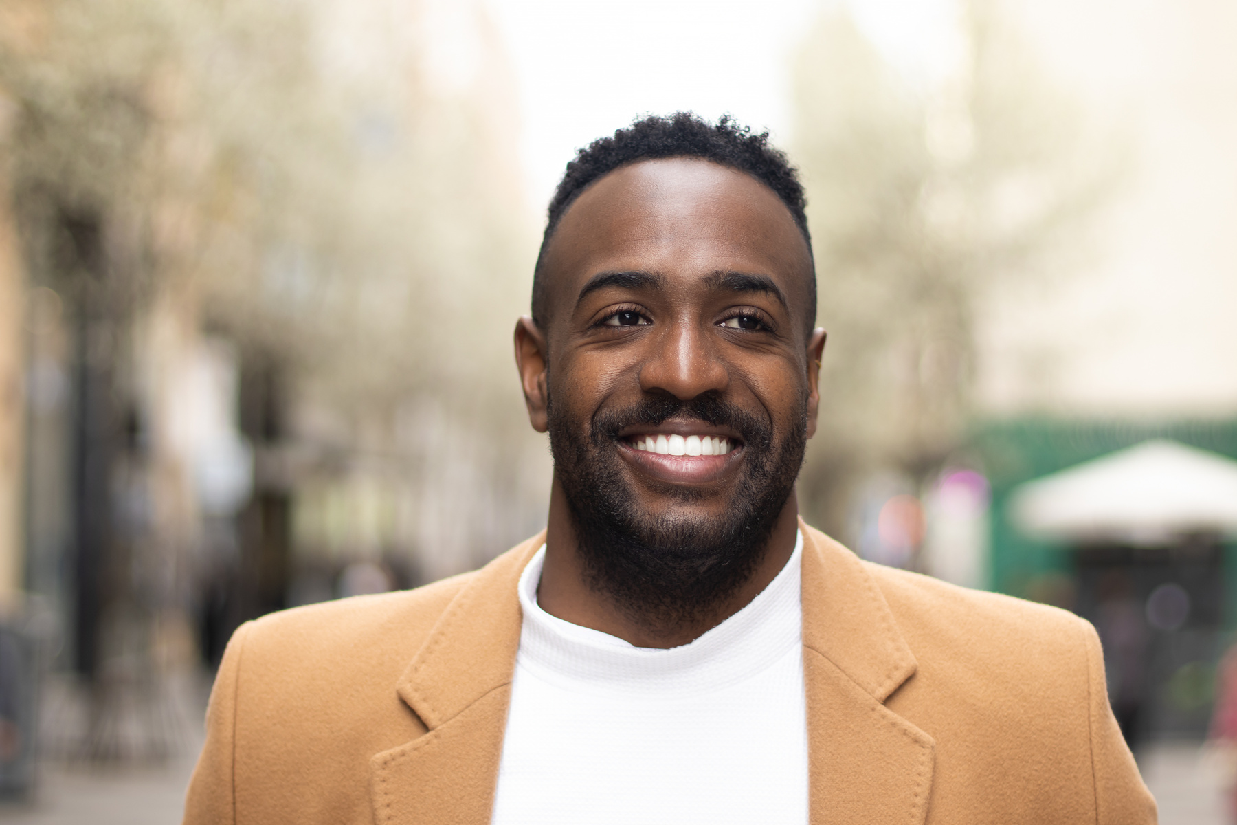 Smiling Man in Brown Coat Outdoors