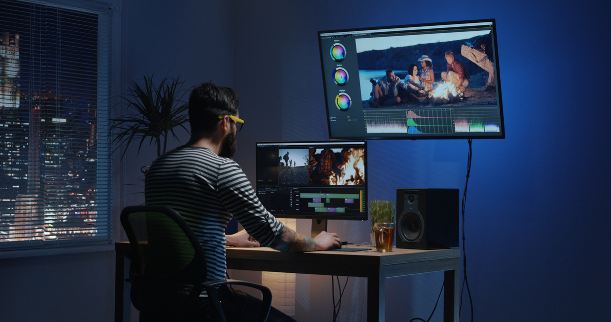 Young man sitting back and editing video inside a room