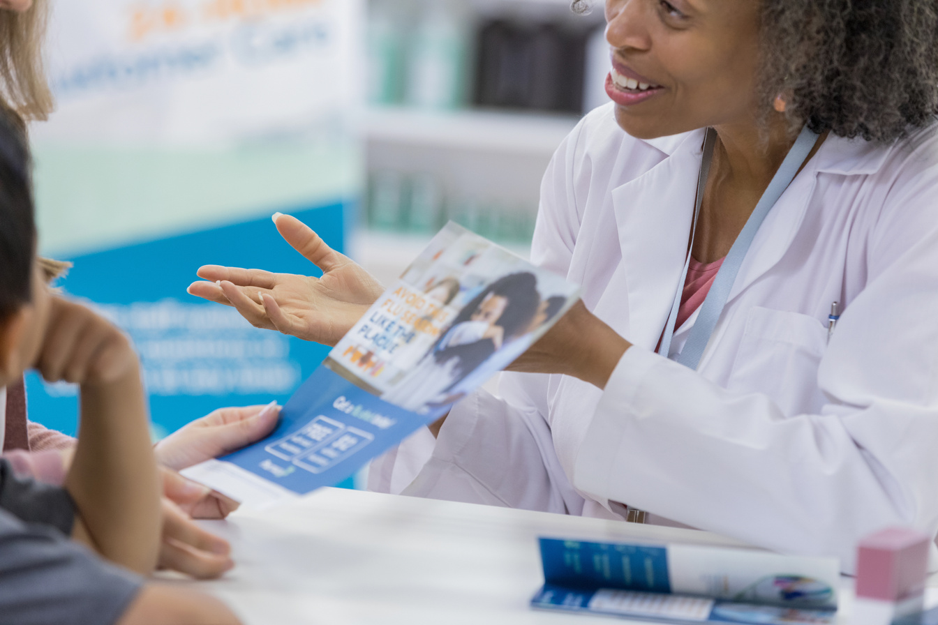 Pharmacy customer reads flu vaccine flyer