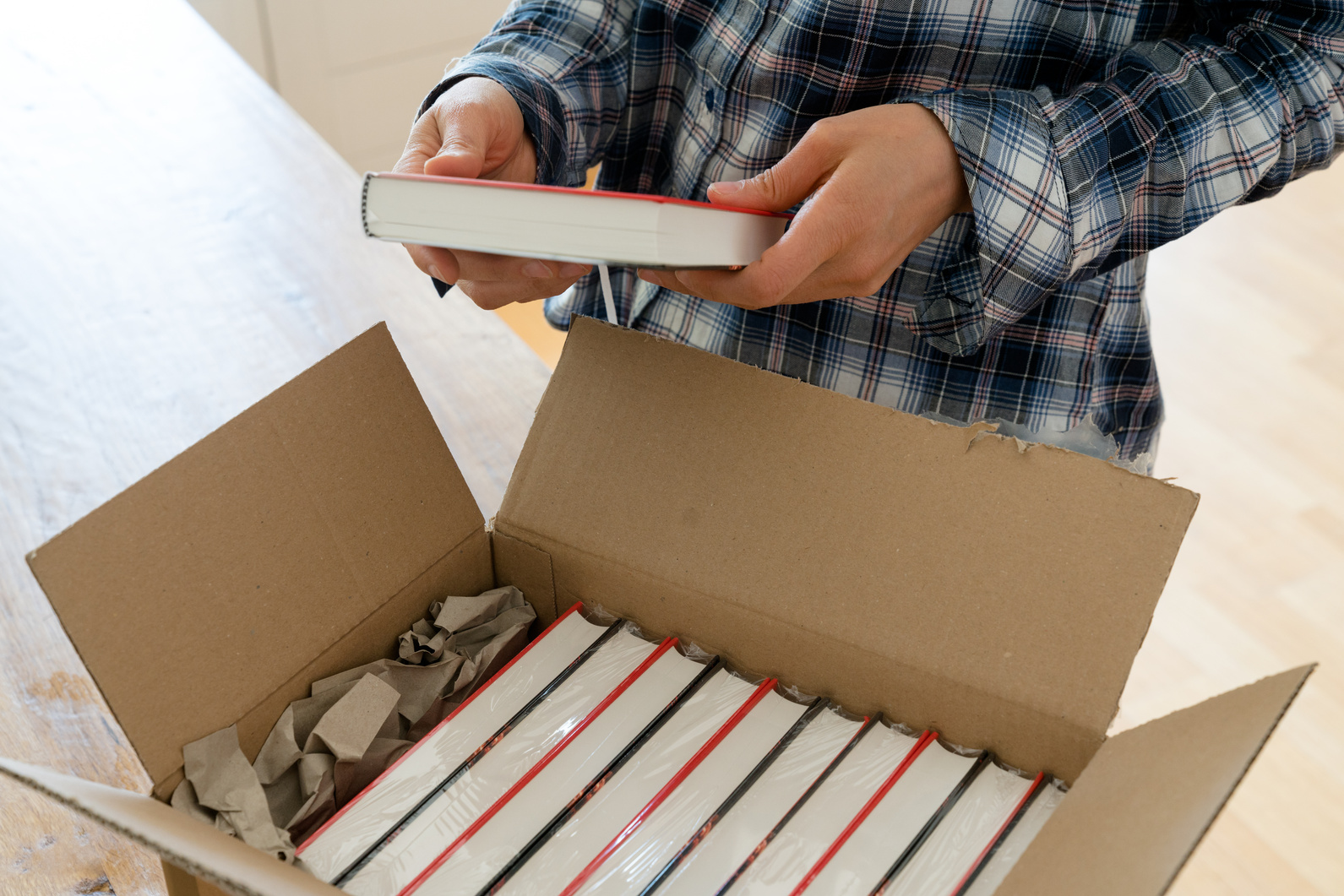 author opens package with samples of her new book and checks the hardcover 